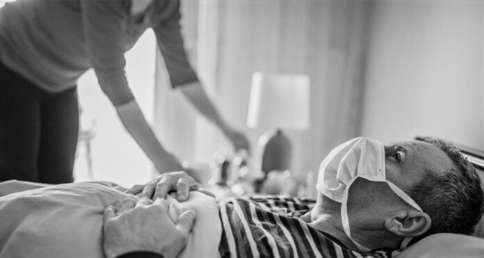 man has symptoms of the virus, lies in bed